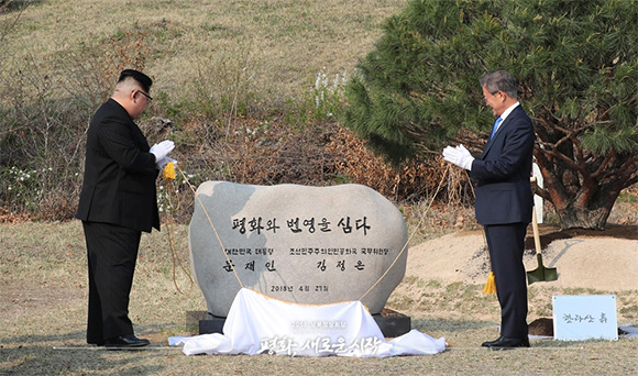‘소떼길’에 평화와 번영을 상징하는 1953년생 소나무를 기념식수 하는 문재인 대통령과 김정은 국무위원장.