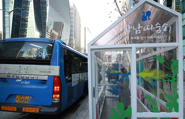 서울 강남구 테헤란로 버스정류장에 설치된 '강남따숨소'에서 시민들이 버스를 기다리며 추위를 피해 몸을 녹이고 있다