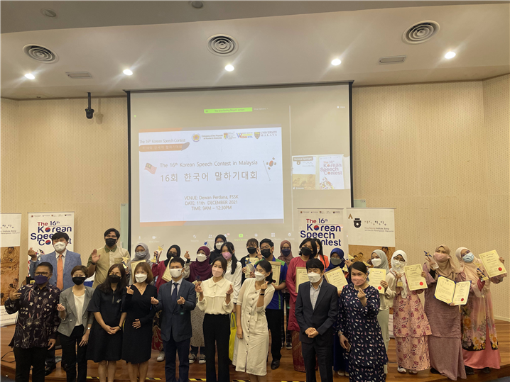 <한국어 말하기 대회 참가자들과 심사위원이 함께 기념 사진을 촬영하고 있다>